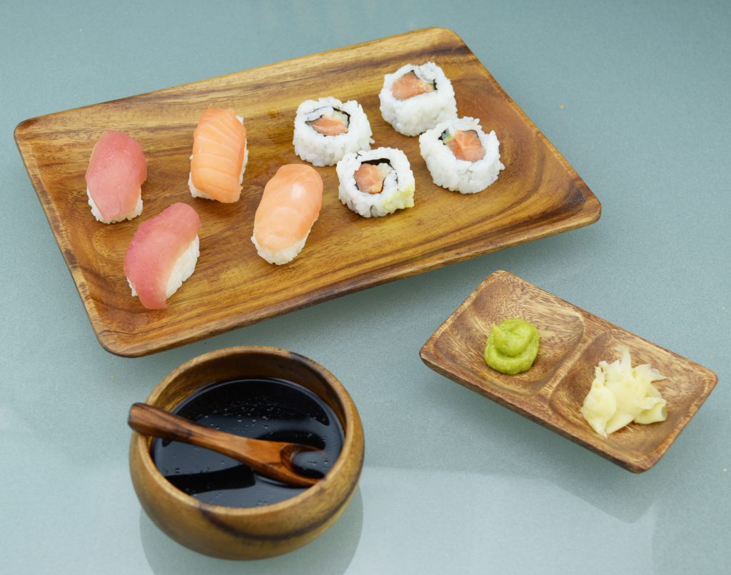 Sushi on wood serving tray and soy sauce in dipping bowl